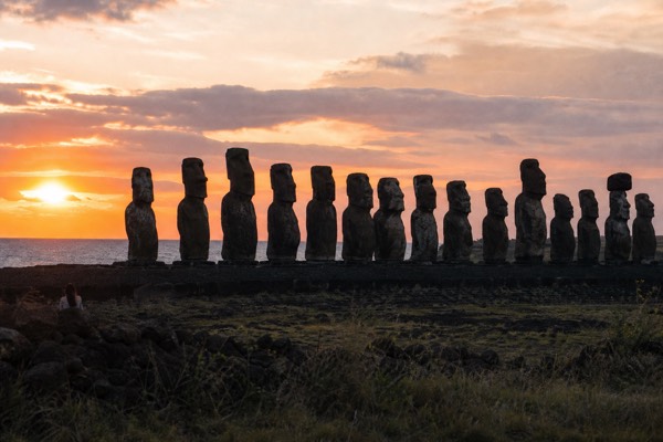 Fifteen moai of Ahu Tongariki silhouetted at sunrise on Easter Island with the Pacific horizon glowing