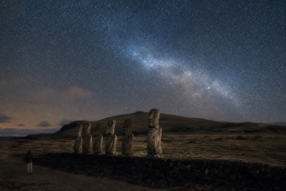 Dense southern star field and the Milky Way arching over a dark volcanic ridge with no artificial light