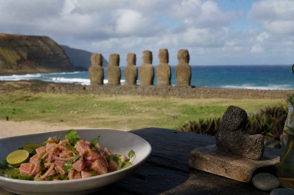 Plate of fresh tuna ceviche with lime and coriander on an outdoor table overlooking the ocean