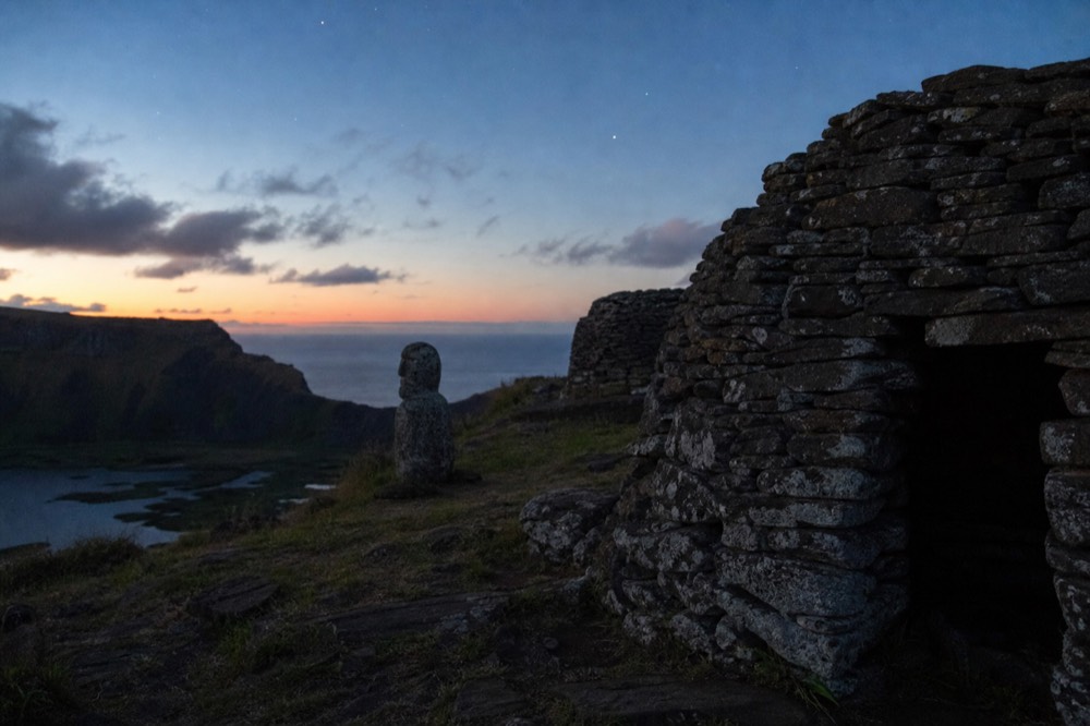 Stone huts of the Orongo ceremonial village perched on the narrow rim above the Rano Kau crater lake