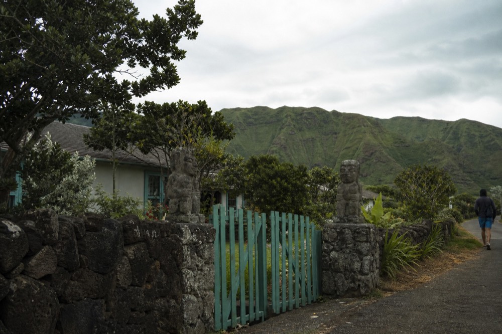Painted wooden gate and low stone wall at the entrance to a small guesthouse on a quiet residential lane